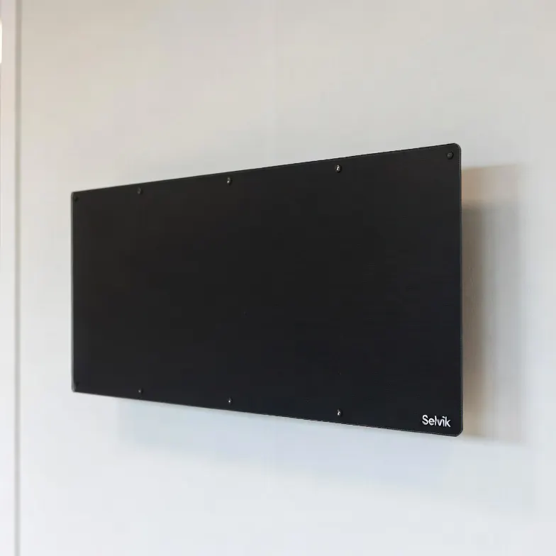 Panel calefactor infrarrojo Selvik INFRA 700 negro en una pared blanca